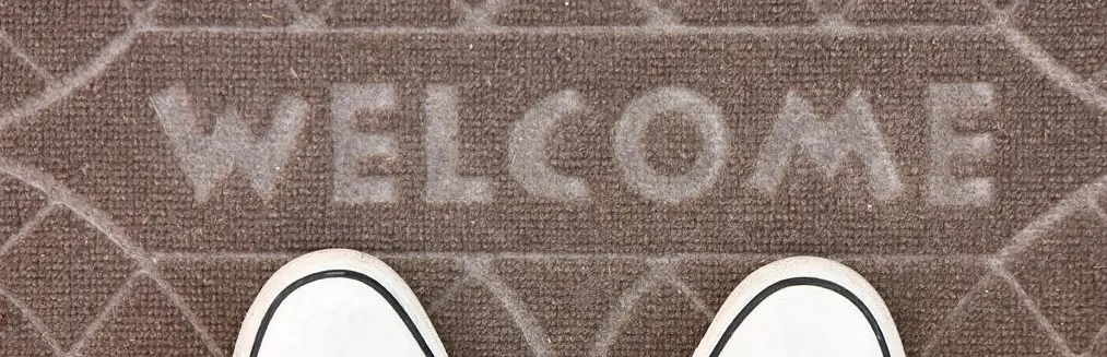 Welcome mat with shoes standing on it